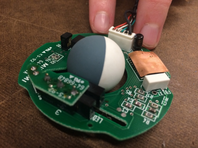 image of inside of Apple Hockey Puck mouse, integrated circuit and rollerball