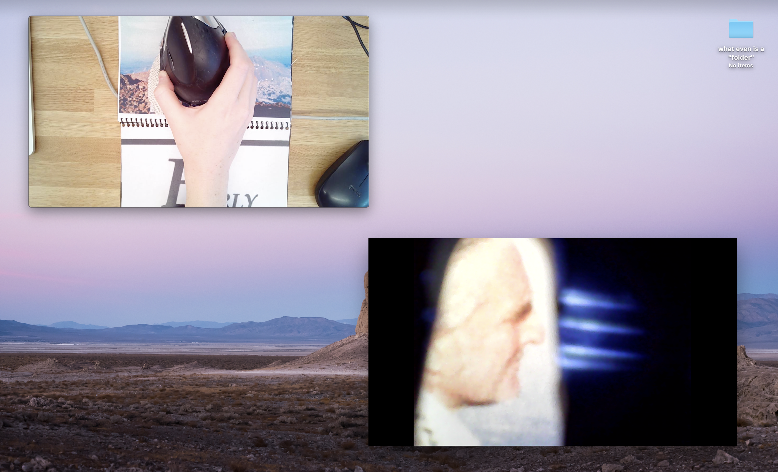 Screenshot of desktop. One video feed of vertical mouse housing an endosopic camera hovering over a mouse pad that is also a book. One video feed from endoscopic camera, in this case a part of Doug Engelbart's face